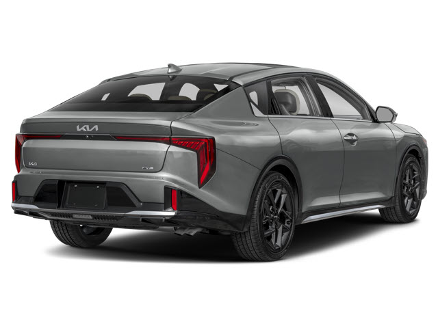 A sleek gray 2025 Kia K4 car viewed from the rear, showcasing sporty design and black accents.